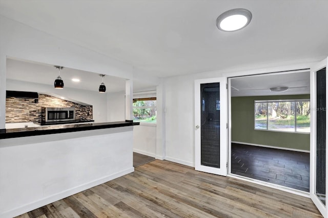 kitchen featuring backsplash, vaulted ceiling, wood-type flooring, and decorative light fixtures