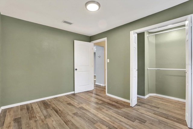 unfurnished bedroom featuring light wood-type flooring and a closet