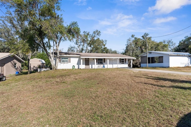 ranch-style house featuring covered porch and a front yard