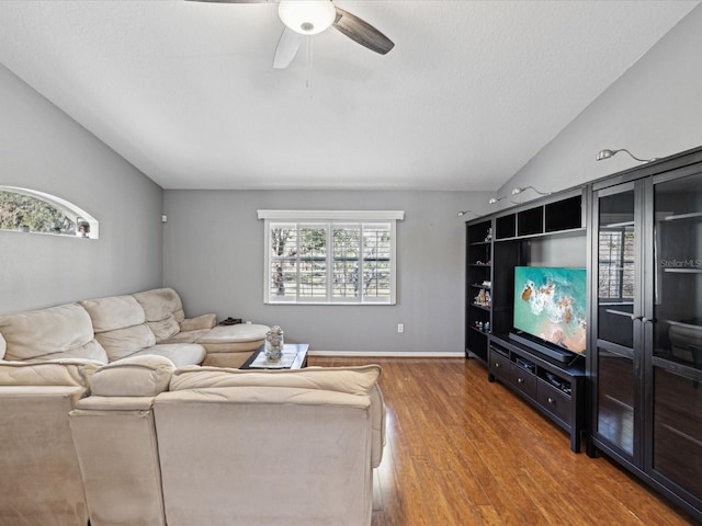 living room with hardwood / wood-style flooring, vaulted ceiling, and ceiling fan