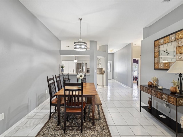 dining space with light tile patterned floors and a notable chandelier