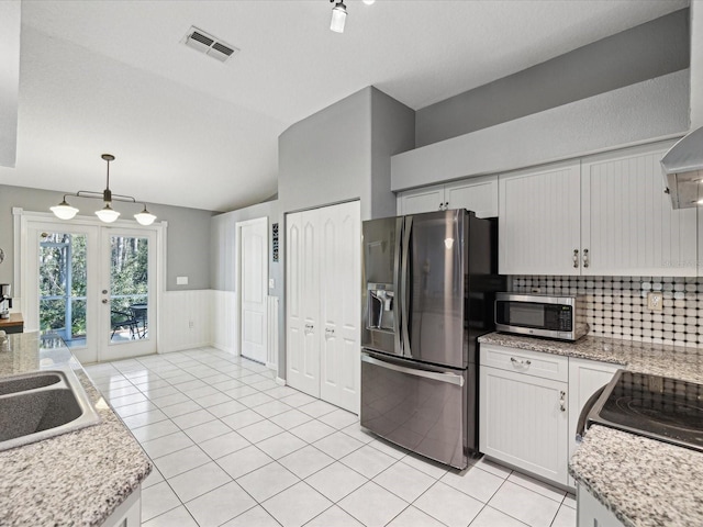 kitchen featuring white cabinetry, french doors, stainless steel appliances, decorative light fixtures, and light tile patterned flooring