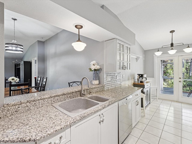 kitchen featuring white cabinets, dishwasher, and lofted ceiling