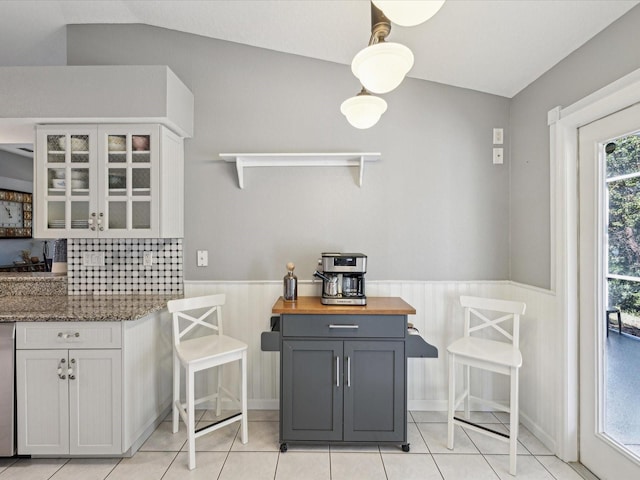 kitchen featuring gray cabinetry, wood counters, white cabinetry, and lofted ceiling