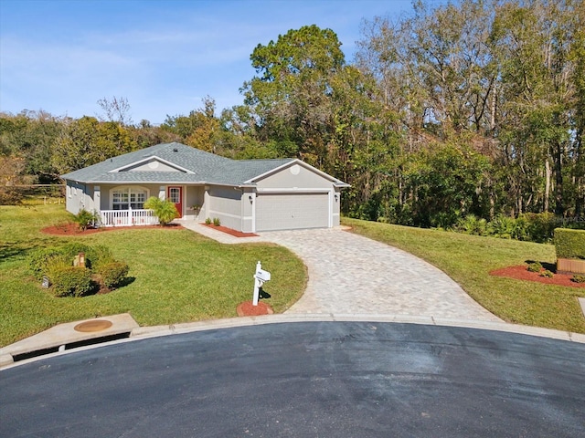 ranch-style house featuring covered porch, a garage, and a front lawn