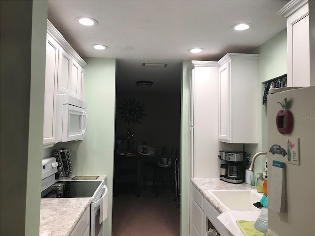 kitchen featuring white cabinetry, sink, and white appliances