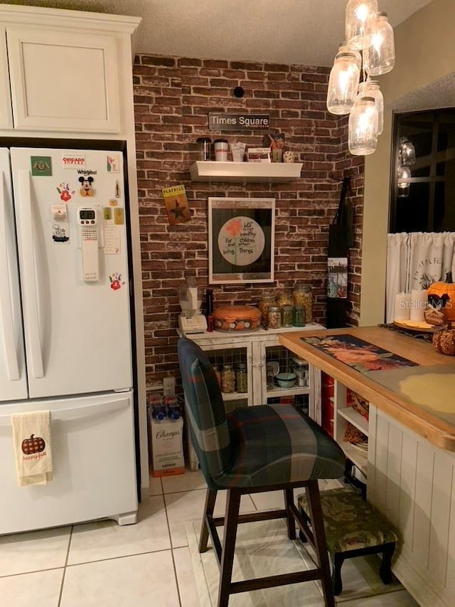 tiled dining area featuring brick wall