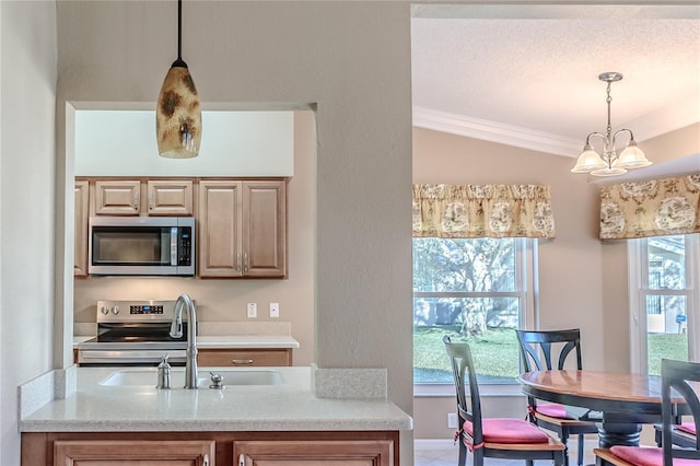 kitchen featuring sink, stainless steel appliances, an inviting chandelier, pendant lighting, and ornamental molding