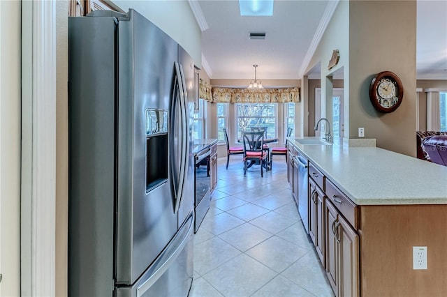 kitchen with stainless steel appliances, crown molding, sink, a notable chandelier, and hanging light fixtures