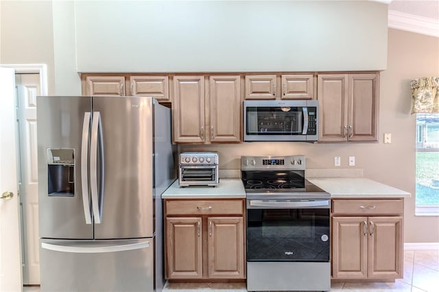 kitchen with light tile patterned floors, stainless steel appliances, and ornamental molding