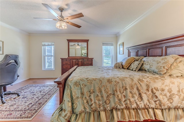 bedroom featuring ceiling fan, light hardwood / wood-style floors, crown molding, and a textured ceiling