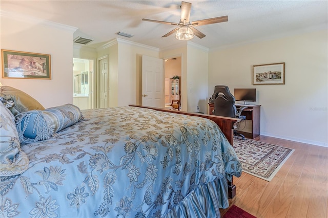 bedroom with hardwood / wood-style flooring, ceiling fan, crown molding, and connected bathroom