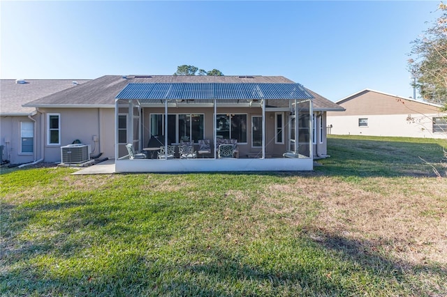 back of property with a lawn, a lanai, and central AC