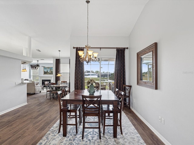 dining space featuring ceiling fan with notable chandelier and dark wood-type flooring