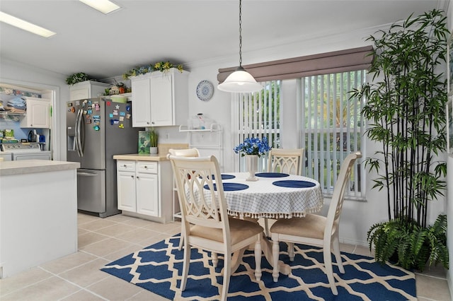 dining space with separate washer and dryer, light tile patterned floors, and ornamental molding