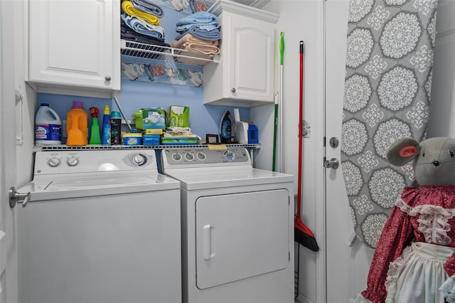 laundry area featuring washer and clothes dryer and cabinets