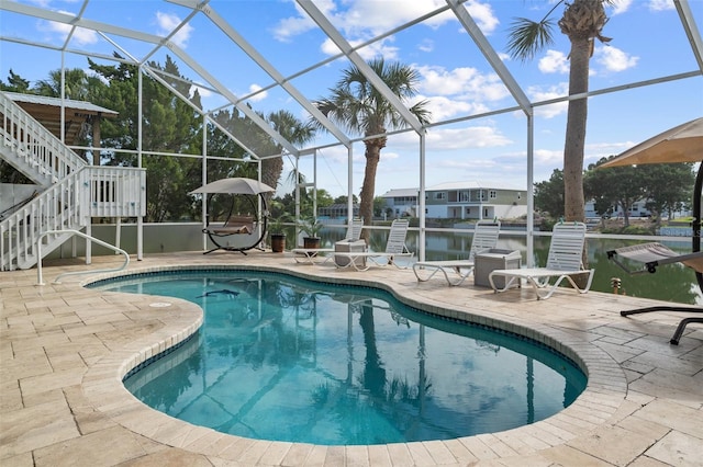 view of swimming pool with a patio area, a water view, and glass enclosure