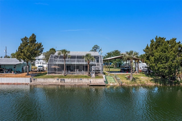 back of house with a water view and glass enclosure