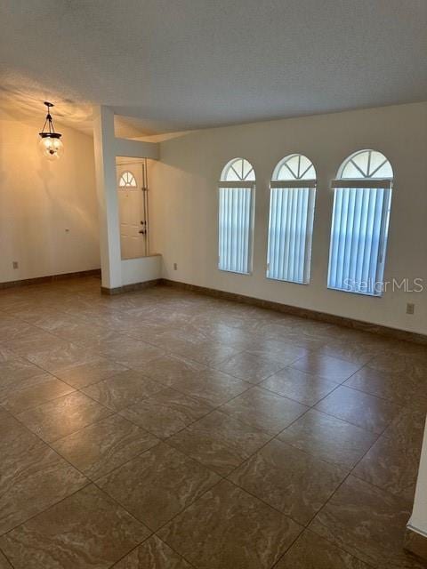 empty room with a healthy amount of sunlight and a textured ceiling