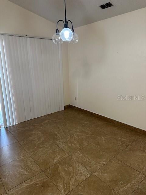 unfurnished dining area featuring a notable chandelier and vaulted ceiling