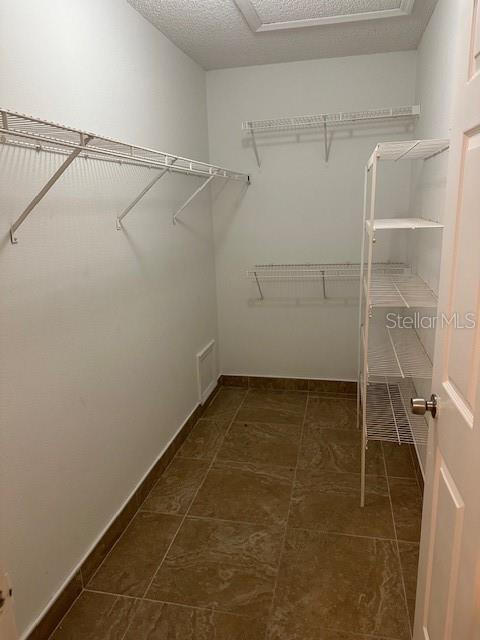 walk in closet featuring dark tile patterned floors