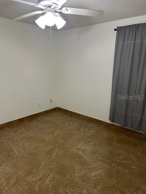 spare room featuring a textured ceiling and ceiling fan