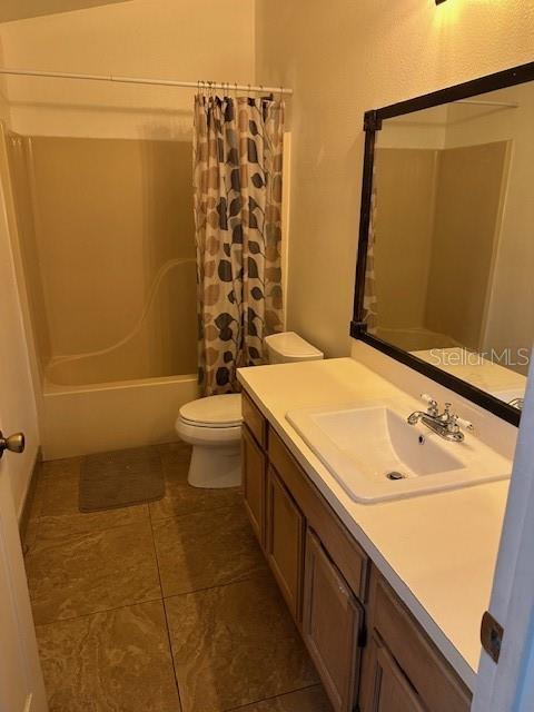 full bathroom with vanity, shower / bath combination with curtain, and toilet