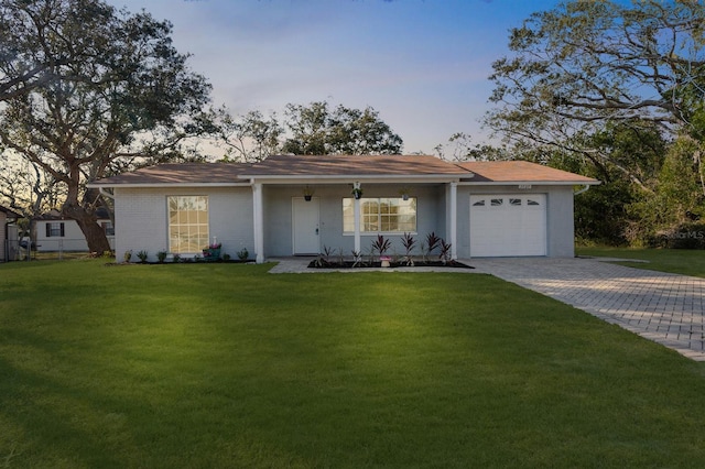 single story home with a lawn, a porch, and a garage