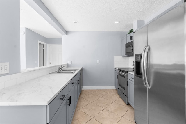 kitchen featuring gray cabinetry, sink, tasteful backsplash, light tile patterned flooring, and stainless steel appliances