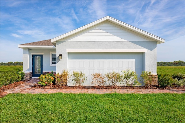 view of front of home with a front yard and a garage