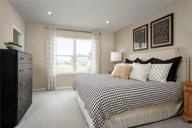 bedroom featuring light colored carpet and a textured ceiling