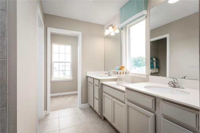 bathroom featuring tile patterned flooring, vanity, and a healthy amount of sunlight