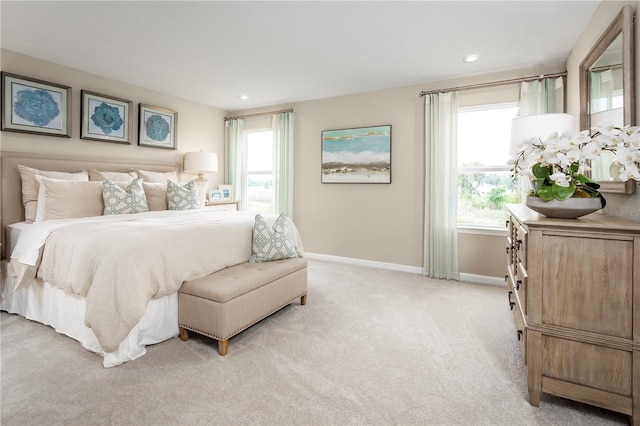 bedroom featuring light colored carpet and multiple windows