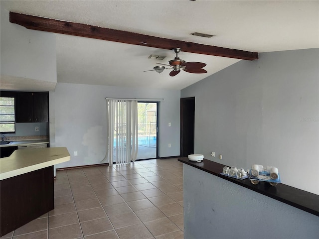 kitchen with ceiling fan, lofted ceiling with beams, and light tile patterned floors