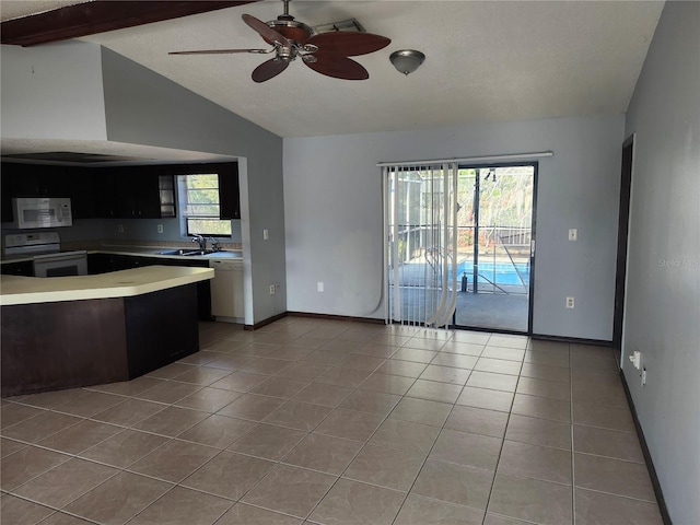 kitchen featuring white appliances, lofted ceiling with beams, sink, and light tile patterned floors