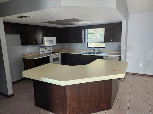 kitchen featuring sink, a textured ceiling, white appliances, light tile patterned floors, and a kitchen island