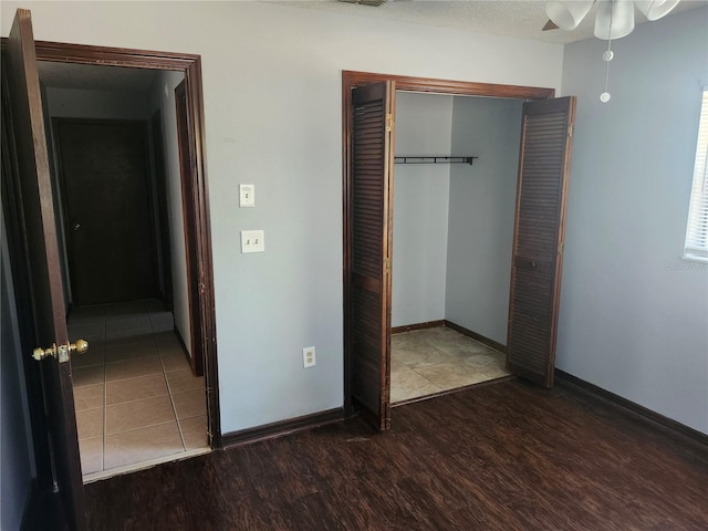 unfurnished bedroom with a closet, ceiling fan, and dark hardwood / wood-style flooring