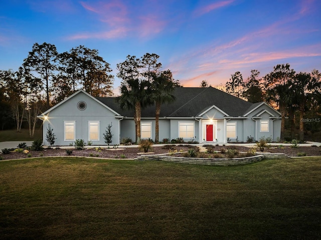 ranch-style home with a yard