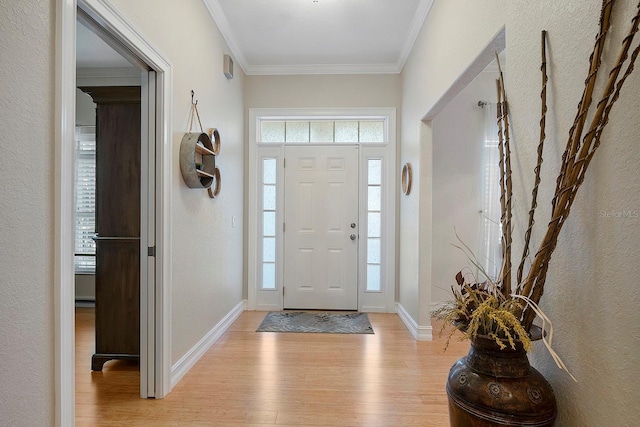 entryway with light hardwood / wood-style floors, crown molding, and a wealth of natural light