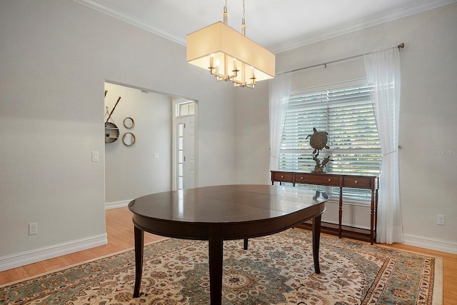 dining space with hardwood / wood-style floors, a notable chandelier, and ornamental molding