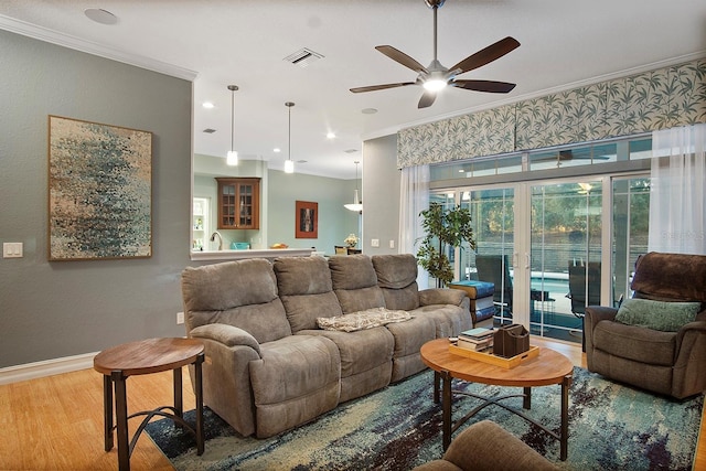 living room featuring hardwood / wood-style floors, french doors, ceiling fan, and ornamental molding