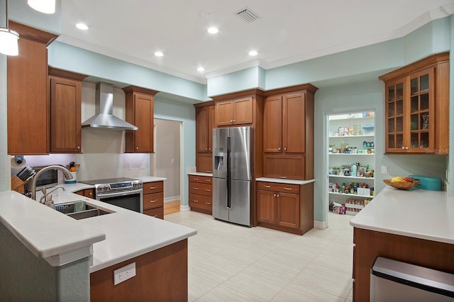 kitchen with sink, wall chimney range hood, crown molding, pendant lighting, and appliances with stainless steel finishes