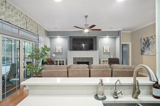 living room with hardwood / wood-style floors, ceiling fan, ornamental molding, and sink