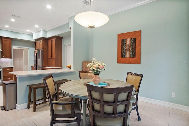 dining space featuring light tile patterned flooring and ornamental molding