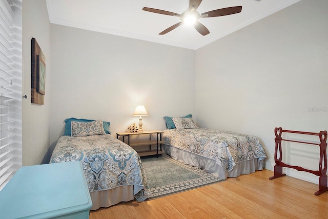 bedroom featuring hardwood / wood-style flooring, ceiling fan, and ornamental molding