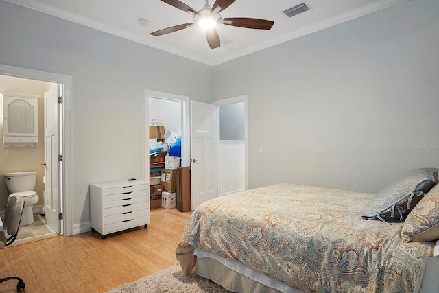 bedroom featuring ensuite bath, ceiling fan, crown molding, and light wood-type flooring