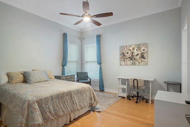 bedroom with hardwood / wood-style flooring, ceiling fan, and crown molding