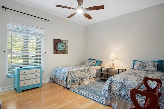 bedroom featuring ceiling fan, crown molding, and light hardwood / wood-style flooring