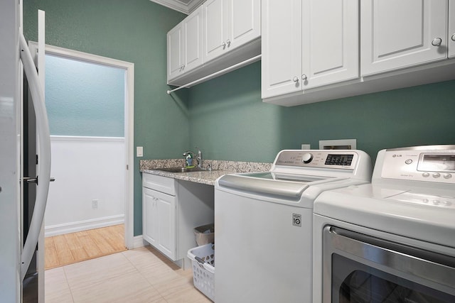 laundry area with cabinets, crown molding, sink, independent washer and dryer, and light tile patterned floors