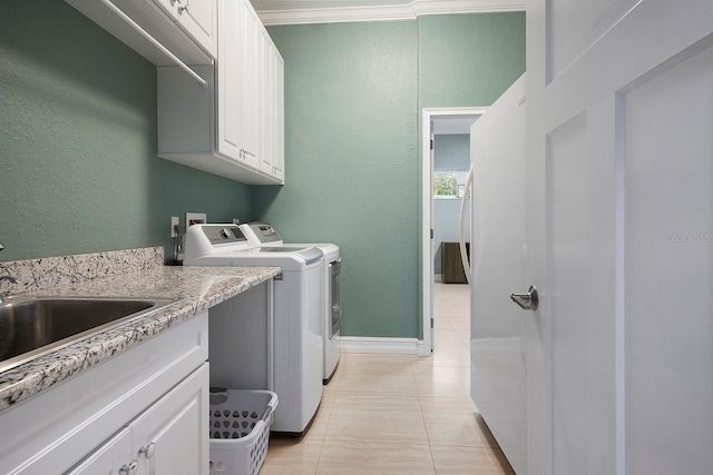 laundry area with sink, cabinets, separate washer and dryer, crown molding, and light tile patterned floors